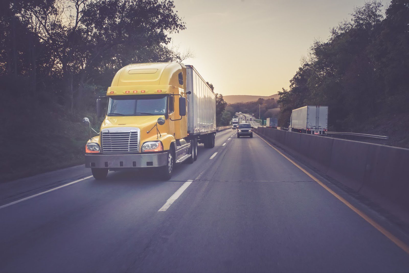 Yellow 18 wheeler truck on highway.